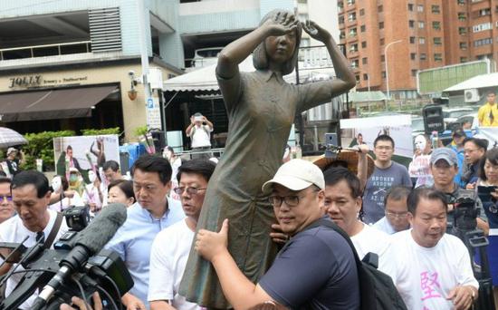 抗议民众携带慰安妇铜像至“台日交流协会”前抗议。（图：台媒）