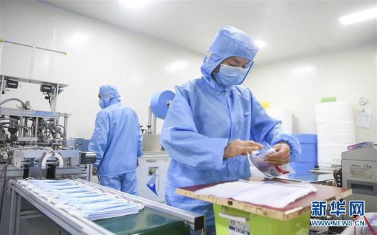 2月11日,工作人员在位于重庆市南岸区的宏冠医疗设备有限公司口罩车间内作业。新华社记者王全超摄
