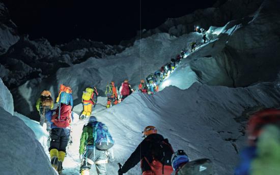 5月22日,昆布冰川中搭了十幾部梯子以幫助登山者通過溝壑高坡,攀登者在前面排起長隊準備依次通過。攝影/Rocker