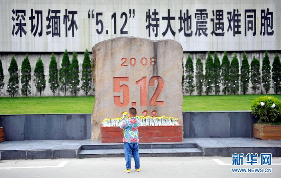 2014年5月11日，一名小朋友在北川老县城祭奠。当日，陆续有北川群众和从各地赶来的人们在北川老县城悼念在汶川地震中遇难的亲友，寄托哀思。图源：薛玉斌|新华社