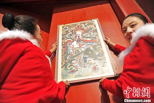 资料图:辽宁沈阳,工作人员于“小年”当天在沈阳故宫内悬挂门神(昊声 摄)