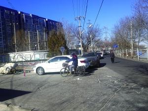 永定河路两侧没有划停车位，但路边停放了多辆车。（图片来源：北京晨报）