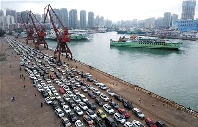 2月21日，在海口秀英港，大量车辆等待过海前往广东徐闻。新华社发