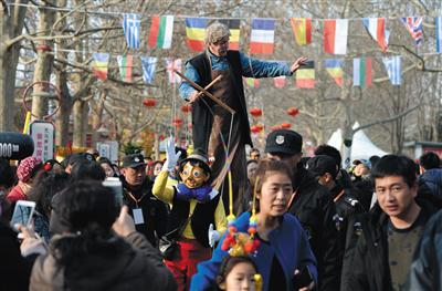 昨日，朝阳国际风情节落幕，两名外国艺人在游客队伍中表演拉线木偶。新京报记者 吴江 摄