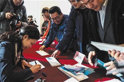 中国邮政大厦，会徽设计者林存真给购买邮票的市民签名。