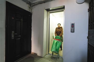 昨日,黄村西里56号楼,大兴区首个老旧楼房加装电梯工程完工。一位居民在使用刚加装好的电梯。新京报记者 吴江 摄