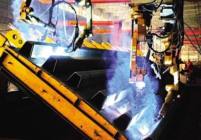 1月25日，中铁山桥集团有限公司的工人在操作焊接机器人焊接钢桥的U型钢箱梁。