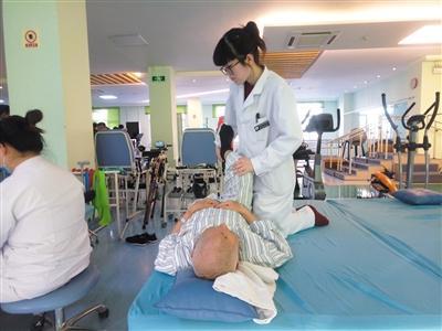 康复治疗师协助病人进行康复训练。
