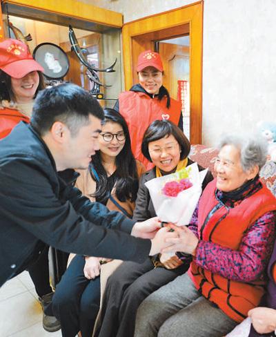 社区志愿者来到孙锦秀（右一）家中看望。资料图片