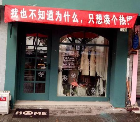 一家服装店门口的无厘头横幅。 杭州网 图