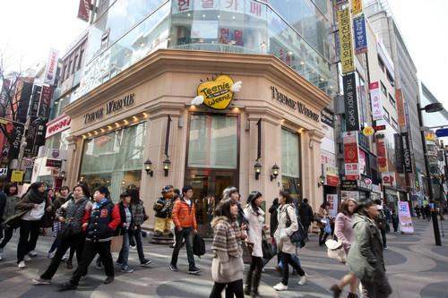资料图片：2011年3月2日，人群经过韩国首尔明洞购物区的一家服装店门口。新华社记者 何璐璐 摄