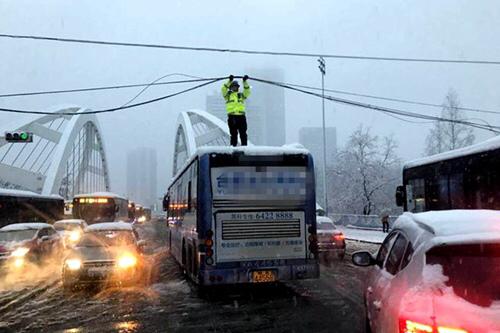 重庆晨报:民警暴雪中托举电缆走红：是光缆 不会拿命开玩笑