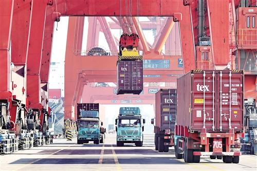 一月十三日,工人在唐山港京唐港区集装箱码头操作机械设备往轮船上吊装集装箱。 新华社记者 杨世尧摄