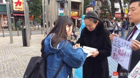 11月11日,江秋莲在东京街头征集签名。