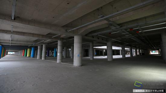 由中国建筑第八工程局承建的北京新机场综合交通中心(停车楼及综合服务楼)项目,地下1层东西贯通,地上3层分为东西两个停车楼,共设成为5345个,其中充电桩车位600个,其布局呼应主航站楼分区运行的功能流程,东西两个独立停车单元分别服务东西侧航站楼旅客(2月23日摄 图片来源:tuku.qianlong.com)。千龙网记者 陈健男摄