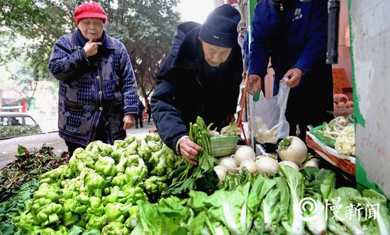 菜店老板说，周老寿星挑选蔬菜是一把好手。