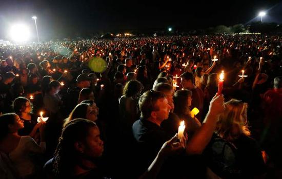 2月15日，在美国佛罗里达州南部帕克兰市，人们参加悼念枪击案遇难者的烛光守夜活动。帕克兰市一所高中14日发生佛州历史上最严重校园枪击案，造成17人死亡、15人受伤。（新华社/美联）