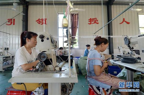 在江西省赣州市石城县小松镇桐江村,村民在“就业扶贫车间”内工作(2017年7月22日摄)。新华社记者 彭昭之 摄