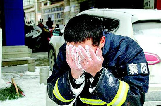 图为：消防战士罗国虎正用雪洗脸