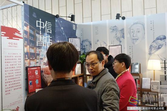 12月7日下午,北京市新闻出版广电局局长杨烁在活动现场正式发布了《2016-2017年度北京市全民阅读综合评估报告》。图为活动开始前杨烁参观优秀书店展示区。千龙网记者 孙梦圆摄