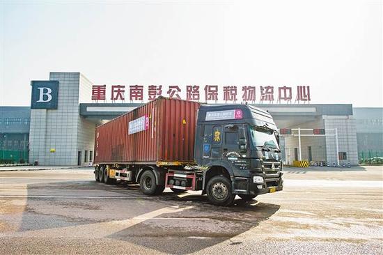 12月20日，装满货物的重庆东盟公路班车从重庆南彭公路保税物流中心驶出。记者 谢智强 摄