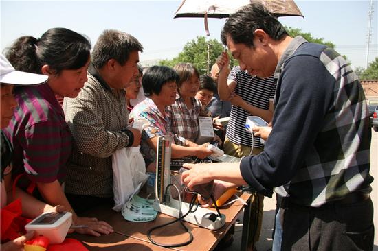 邀请专业医护人员现场为村民检测血压计