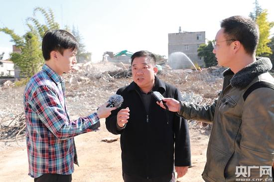 中央人民广播电台赴云南走转改采访团记者肖源、李健飞采访当地拆迁工作负责人 央广网李雪南 彭兆伟 摄