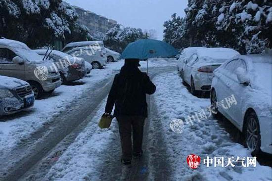 今天早晨，南京某小区市民冒雪出门，路上已经满是积雪。