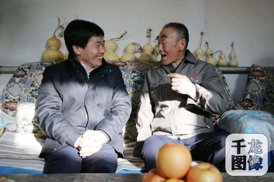 1月19日,2018年“三下乡”活动正式启幕。图为北京市委常委、宣传部长杜飞进(左)以及市“三下乡”成员单位领导带着春节礼包,走到村民家中送上新年祝福。杨连荣摄 千龙网发