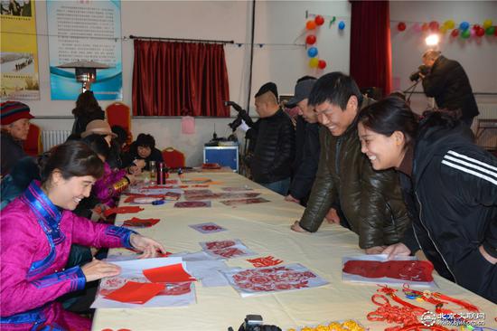 剪纸艺术家刘晓迪为村民讲解自己的作品