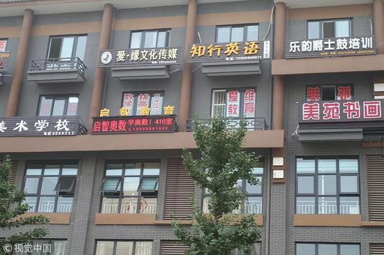 ▲某公寓写字楼布满了各种课外辅导班、教育培训机构的广告牌。  图/视觉中国