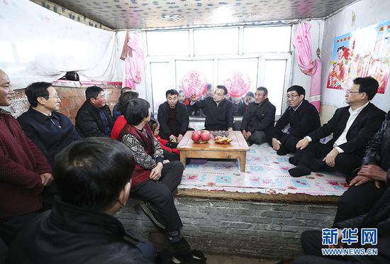 2月12日至13日,中共中央政治局常委、国务院总理李克强在吉林省白城市镇赉县考察。这是2月12日,李克强在镇赉县英华村看望慰问贫困户,同村民亲切交谈。 新华社记者 庞兴雷 摄