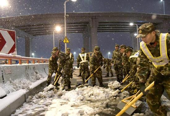 总队官兵分小组协力清理积雪  王亮摄