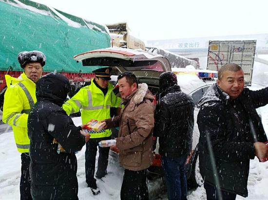 京港澳高速湖北北段的路政、交警、经营公司等部门及时为一些司乘免费送方便面等物资 湖北日报通讯员付学夫 摄