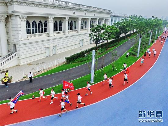  市民在上海黄浦江滨江步道开展健身活动（2017年7月1日摄）。新华社发（蔡耀放 摄）