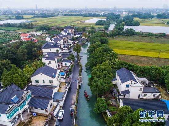 专职保洁人员在浙江省湖州市长兴县龙山街道渚山村车渚港河道内进行河道护理巡查（2017年10月12日摄）。近年来，浙江省湖州市践行“绿水青山就是金山银山”发展理念，大力建设美丽乡村。 新华社记者 徐昱 摄