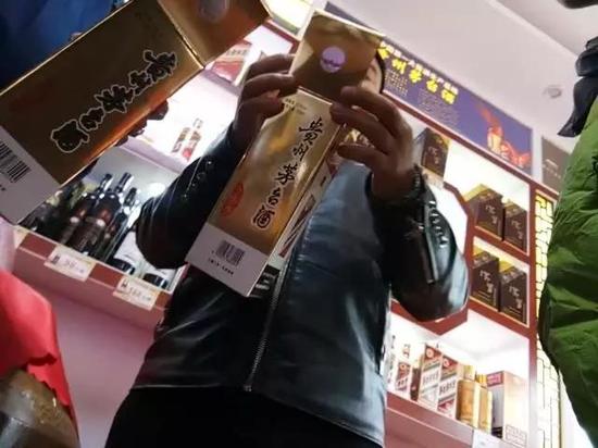 茅台镇的酒铺商家，正在介绍假冒茅台包装的特点。