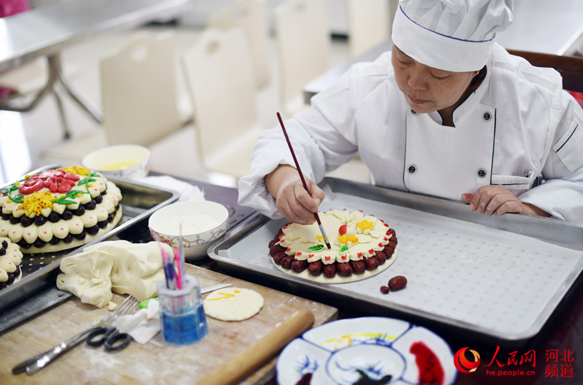  图为河北枣强县邵府村村民李会青正在制作花糕。