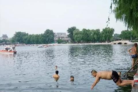 ▲8月25日，什刹海边的游泳者。 新京报记者 王飞 摄