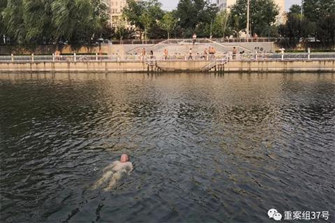 ▲8月25日，东二环护城河，一位游泳者漂浮在水面上。 新京报记者 王飞 摄