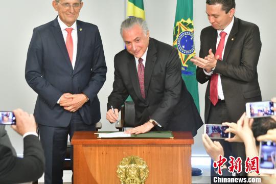 巴西總統特梅爾（中）在總統府簽署“中國移民日”法令。  中新網 圖