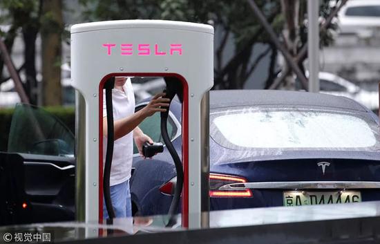 2018年7月11日，北京，一名男子在特斯拉中国总部外为车充电。