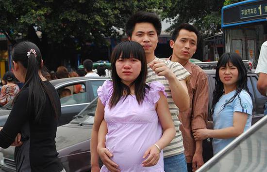 2008年5月12日，绵阳市科委立交桥长虹大道，地震发生时，惊恐中的人们冲出房屋，冲向空旷的地带。图为一男子陪着怀孕的妻子站在街头。