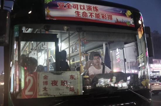2018年7月11日晚9点多，河南新密，在一个公交站前，张海超正在等乘客上下车。新京报记者尹亚飞 摄