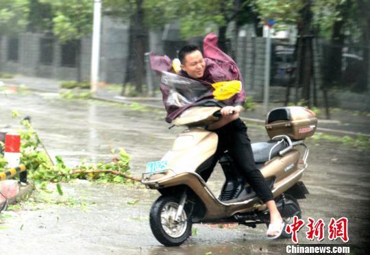 图为路人艰难骑行。 王东明 摄