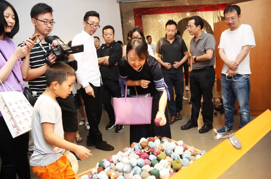 艺术家司建伟为到展观众介绍他与母亲共同完成的作品《缝补记忆》。