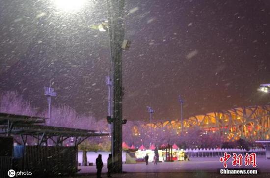 11月29日晚,北京入冬初雪出現,夜幕降臨,奧森公園雪花飄落。圖片來源:ICphoto