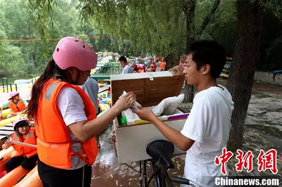  游客在购买赵龙的冰棍。
