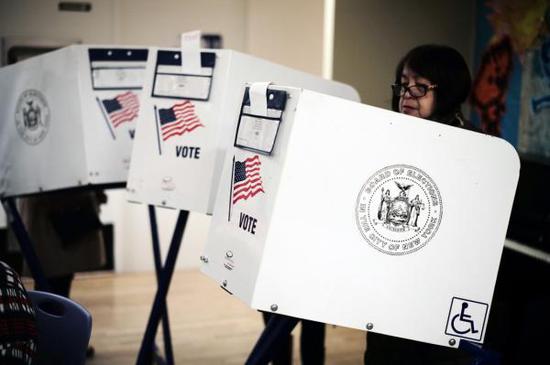 11月6日，在美国纽约曼哈顿，一名选民在一处投票站填写选票。 新华社 图