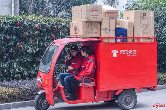 (快递小哥与妻子在京东物流装运快递前往送货)